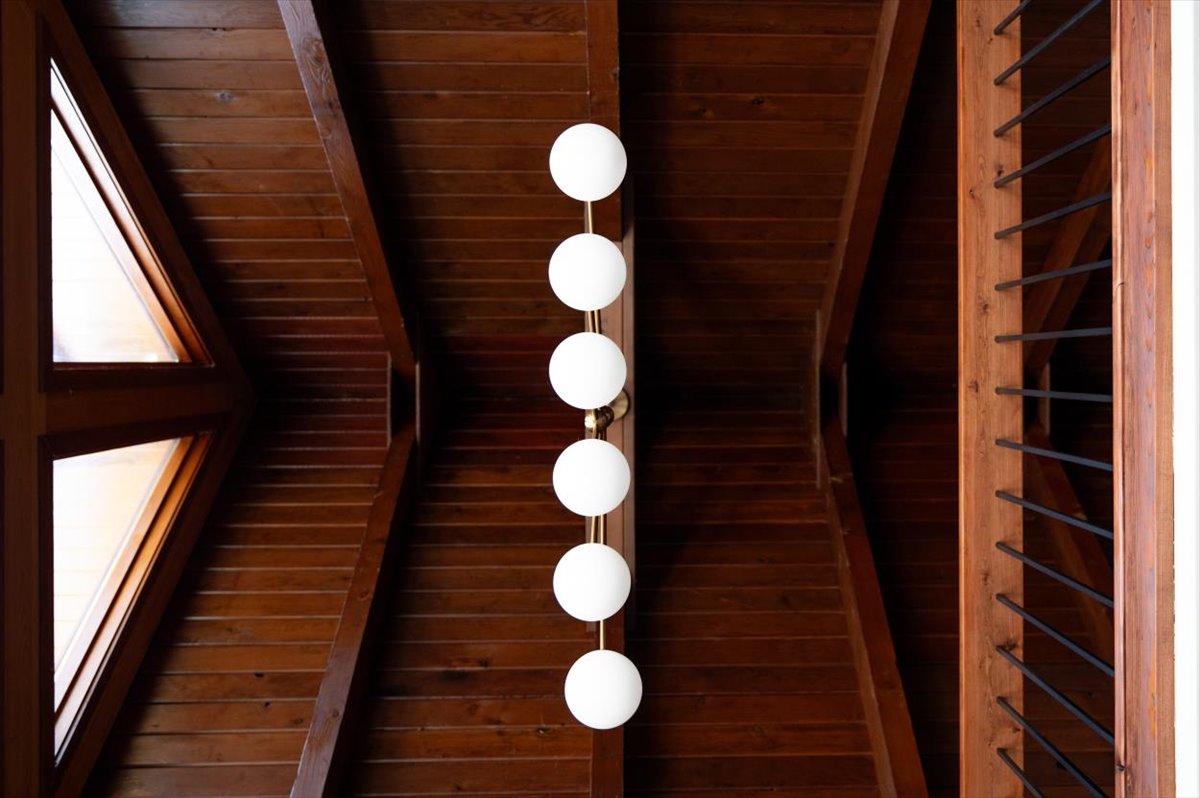 Track lighting mounted along the vaulted A-frame wood ceiling
