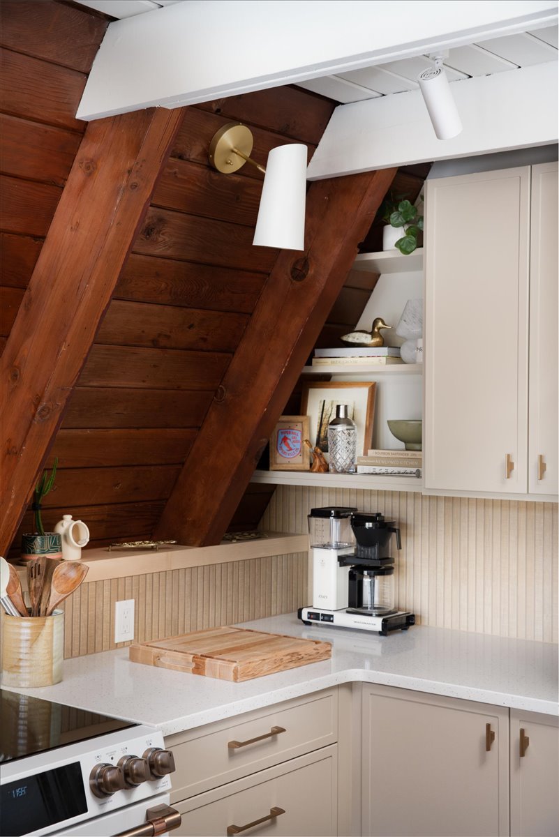 Kitchen counter and sconce detail beneath the sloped wood A-frame wall