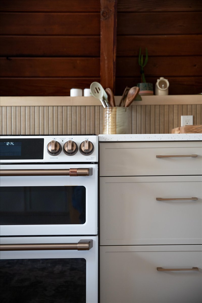 Range and white cabinetry detail in the renovated A-frame kitchen