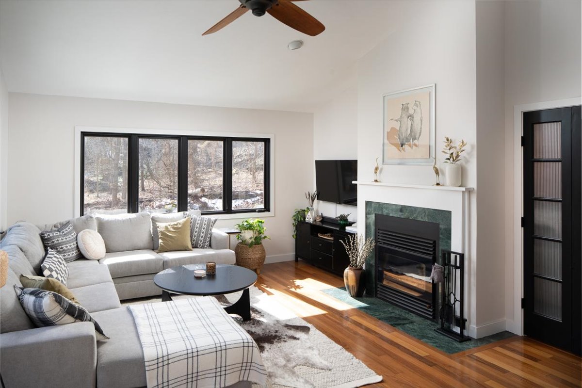 Secondary lounge with sofa, coffee table, black fireplace, and framed artwork