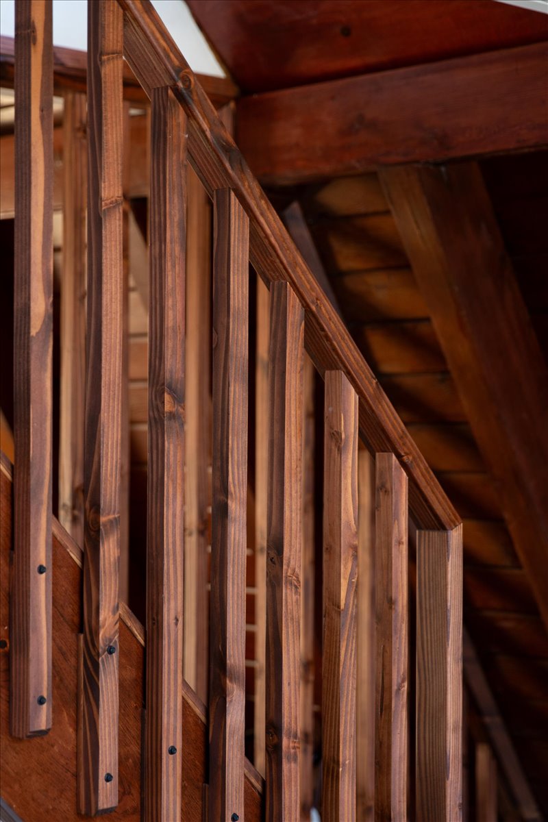 Custom slat wall and railing beside the stair in stained wood