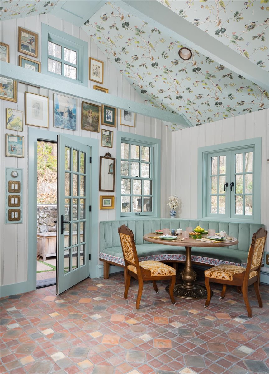 Built-in dining banquette with pale blue-green trim and patterned ceiling