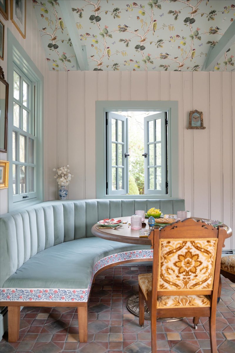 Dining banquette with upholstered bench, window, and round table