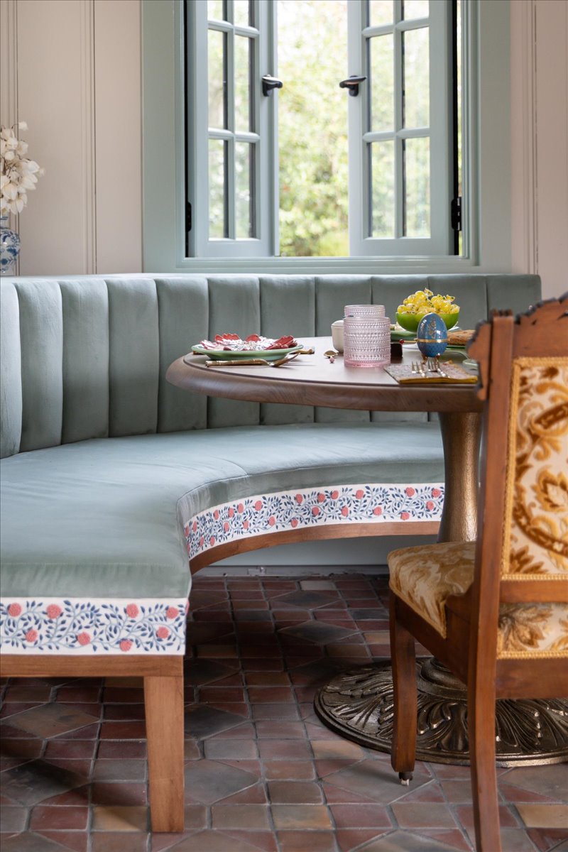 Dining nook detail with patterned bench cushion and wood chair