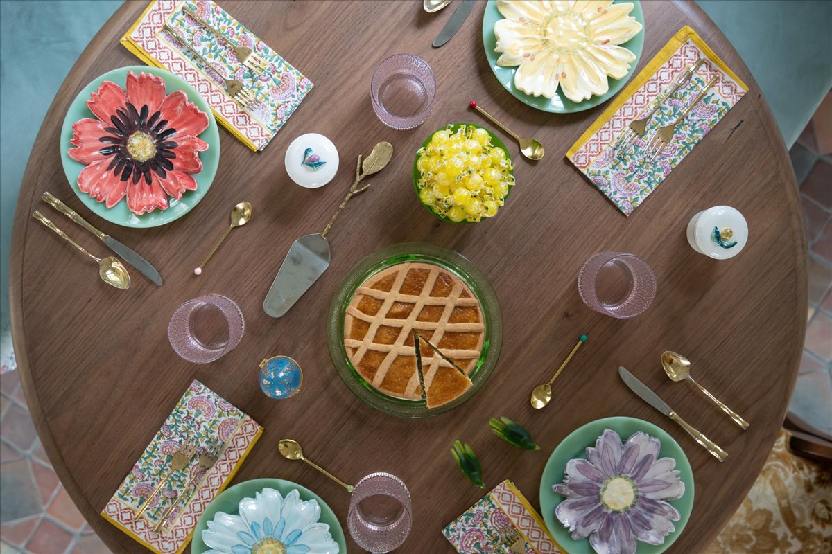 Overhead view of a round dining table with colorful plates and patterned linens