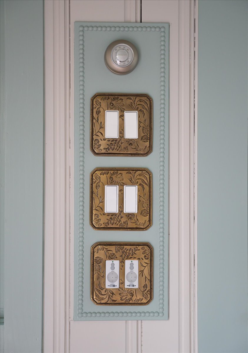Vintage-inspired switch plates set into pale blue-green trim