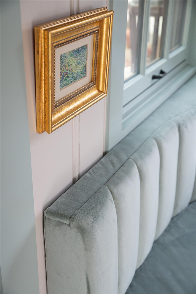 Framed art, painted trim, and upholstered seating detail