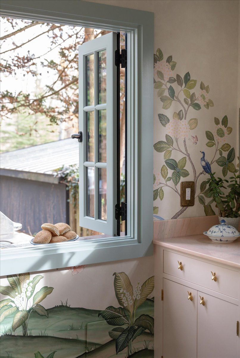 Kitchenette cabinetry and small window facing outdoors